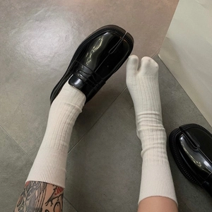 Japanese minimalist vertical stripe tabi socks in white paired with black split-toe loafers