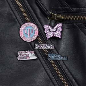 Macro detail of five pink psychology enamel pins attached to a black leather jacket texture