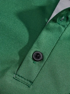 Detalle macro de la tela piqué verde esmeralda transpirable y tapeta de botones polo