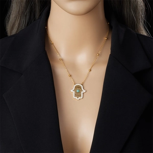 Goldene Hamsa-Halskette mit Türkisstein und Kristallpavé an einem Modeschmuck-Model