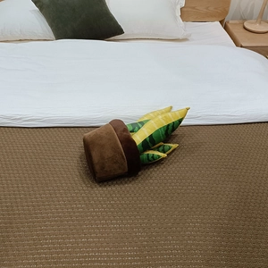 Détail de la peluche plante sansevieria en pot marron sur une couverture tricotée