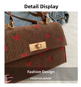 Detailed shot of brown corduroy strawberry embroidery bag with golden metal twist lock