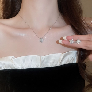 Close-up of elegant silver star jewelry set including necklace and earrings worn by model