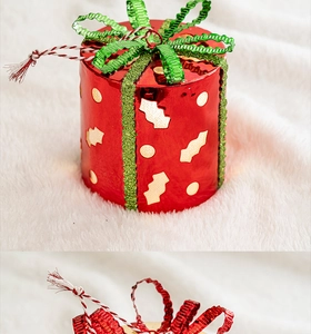 Red cylindrical Christmas gift box ornament with green glitter bow for holiday tree decor