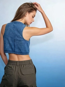Back view of a cropped washed blue denim vest for women with a vintage casual fit