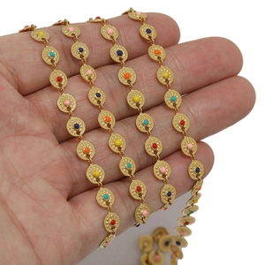 Gold stainless steel sun disc chain with multicolor enamel dots shown on a hand