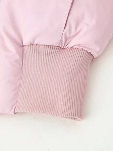 Close-up of pink winter coat sleeve featuring elastic ribbed cuffs and woven fabric