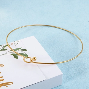 Detail of gold minimalist choker necklace with bead clasp on elegant gift packaging