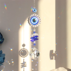 Blue evil eye crystal suncatcher casting rainbow prism light on a white background