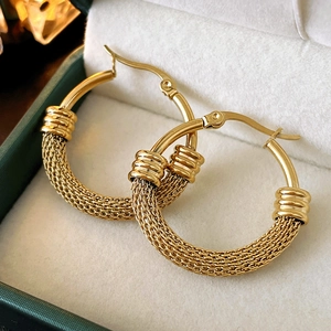 Macro shot of gold-plated hollow mesh texture earrings with polished steel clasps