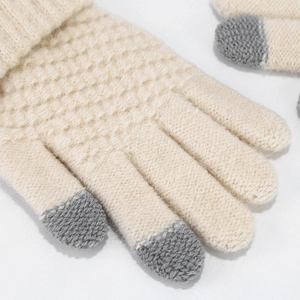 Macro shot of knit gloves showing detailed cream texture and grey touchscreen fingertips