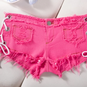 Dettaglio degli shorts in denim rosa acceso con lacci laterali e bordi sfrangiati