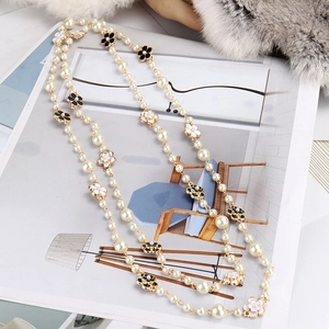 Long pearl necklace for women featuring elegant black and white camellia flower pendants