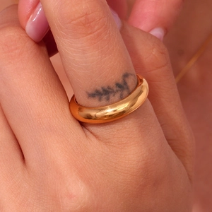 Dettaglio macro dell'anello spesso in acciaio inossidabile placcato oro 18K sulla mano