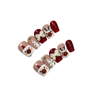 Handmade Christmas press-on nails featuring 3D reindeer, embossed trees and bow accents