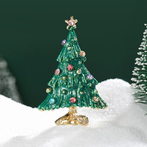 Green enamel Christmas tree brooch with colorful rhinestones on festive snow background