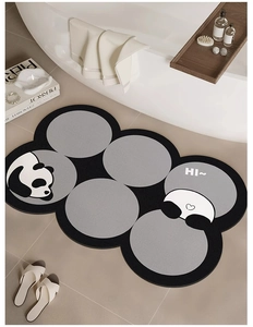 Detail of grey panda shaped absorbent diatom mud bath mat on a modern bathroom tile floor