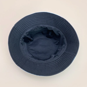 Detailed internal stitching and reinforced brim lines of a black reversible bucket hat