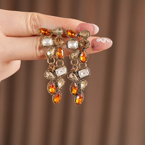 Detail of vintage gold-tone chandelier earrings featuring orange teardrop crystal beads