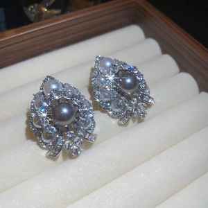Close-up of baroque teardrop earrings with grey pearls and crystals on velvet