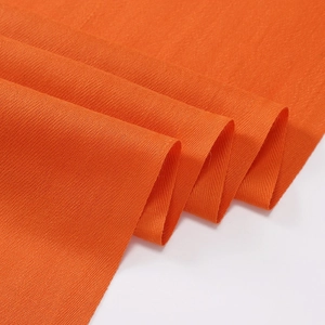 Detailed macro view of orange cashmere-like scarf showing soft woven texture and fiber material