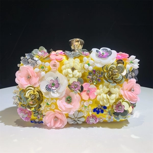 Close-up of bright yellow evening clutch with handmade 3D floral petals and sequins