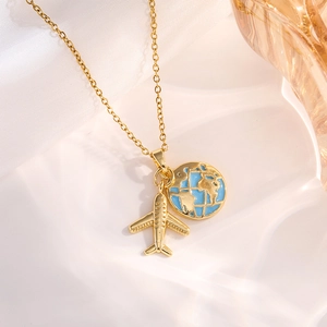 Detail of gold necklace featuring airplane and blue enamel globe charms on silk