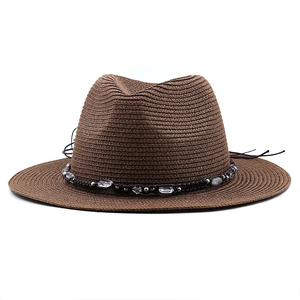 Detail of dark brown woven straw hat with bohemian bead trim and flat top design