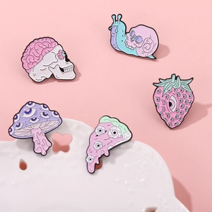Creepy cute enamel pin set with skull strawberry and mushroom on pink lace background
