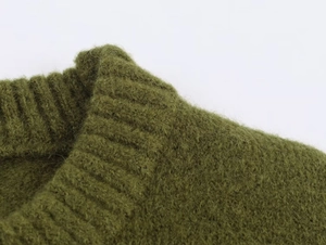 Macro detail of the grass green knit sweater showing ribbing and soft texture