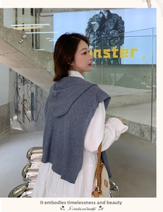 Detail of grey-blue knitted hooded shawl texture and fabric layers on model