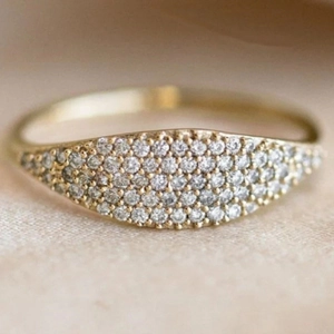 Close-up of gold-plated band ring featuring rows of sparkling pavé-set crystals
