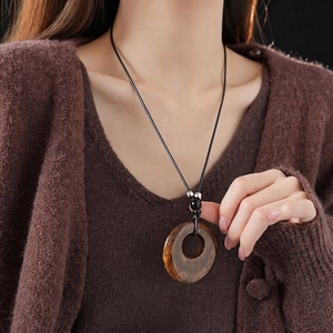 Brown resin hoop pendant necklace on black wax cord with vintage minimalist style