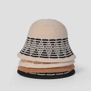 Vertical stack of four knit bucket hats in beige, caramel, and black with jacquard patterns
