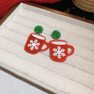 Detail of Christmas mug earrings with white snowflake patterns and sparkling glitter finish