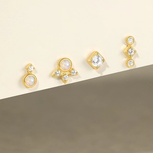 Detailed view of four gold S925 silver stud earrings with opal and cubic zirconia