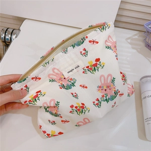 Close-up of cute rabbit floral cotton makeup bag with metal zipper on a white surface