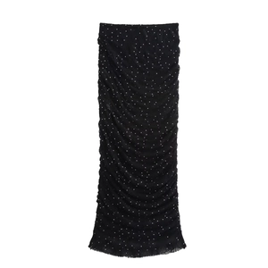 Détail d'une jupe midi froncée noire avec paillettes blanches et texture plissée