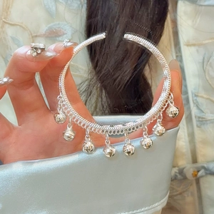 Gros plan du bracelet à clochettes en argent avec détails tressés et grelots