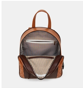Detailed interior of brown leather backpack with classic black and white striped lining