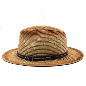 Detail of woven straw hat featuring gradient tones and black leather band with silver buckle