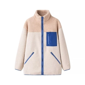 Close-up of fluffy sherpa jacket with blue zipper details and functional chest pocket