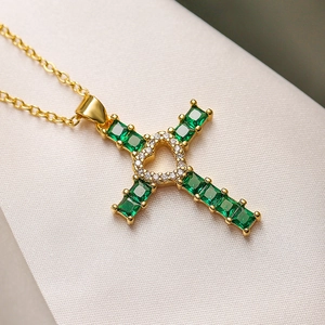 Collier croix avec pierres vertes et cœur en zircon sur une chaîne dorée élégante