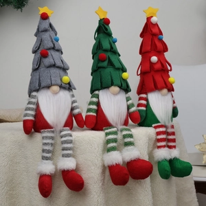Three Christmas faceless gnomes in red, green and grey colors on white plush background