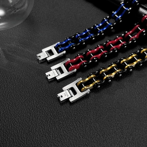 Detail of stainless steel bike chain bracelets in black blue, red, and gold finishes