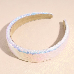 Detailed view of pink sparkling sequins on a wide headband for women against a soft pink background