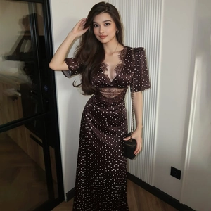 Detail of elegant V-neck polka dot maxi dress with lace trim and slim fit silhouette