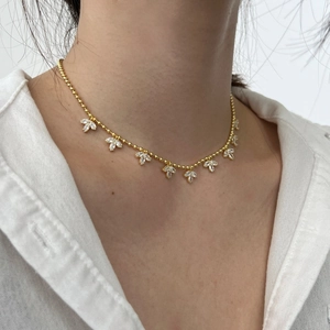 Detail of a gold S925 sterling silver olive leaf necklace with sparkling marquise zircons
