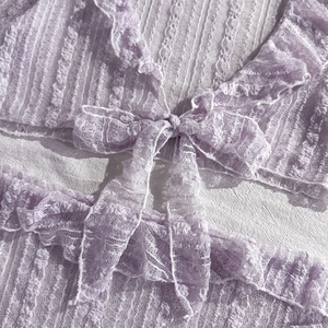 Detail of lavender lace bikini with textured ruffles and center bow tie detail