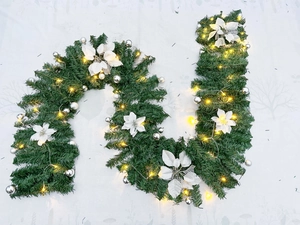 Detailed Christmas garland with white poinsettia, silver baubles and warm LED lights